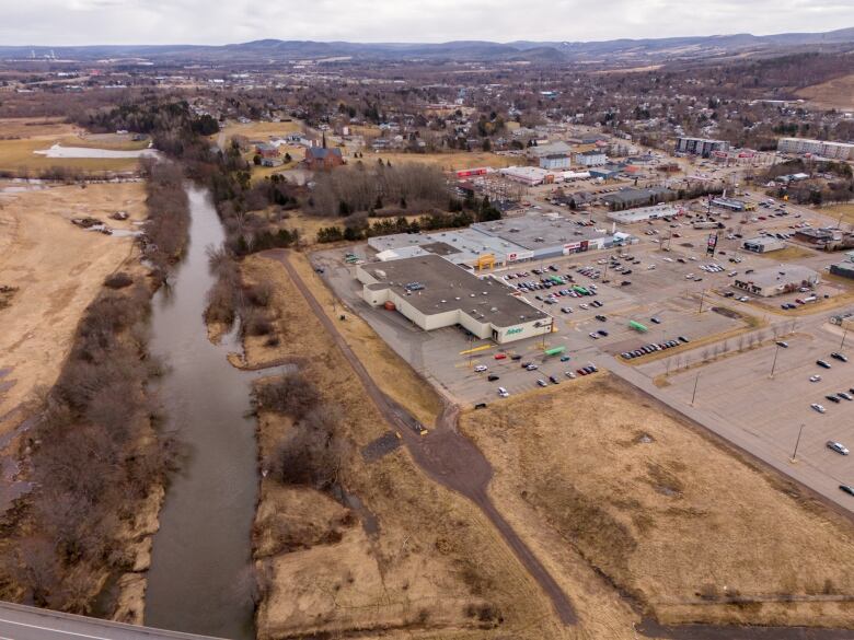 A drone shot of a commerical sprawl area with a large creek running behind it. 