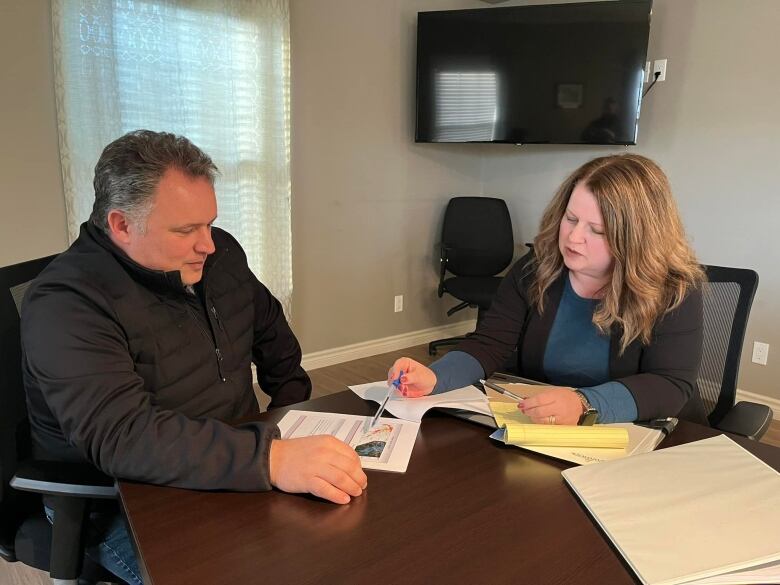 Two government officials look at flood maps. 