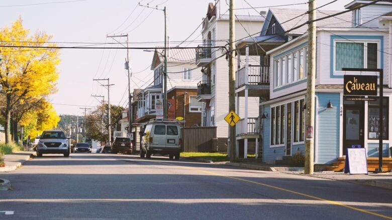 A small town pictured with a few cars parked on the street.