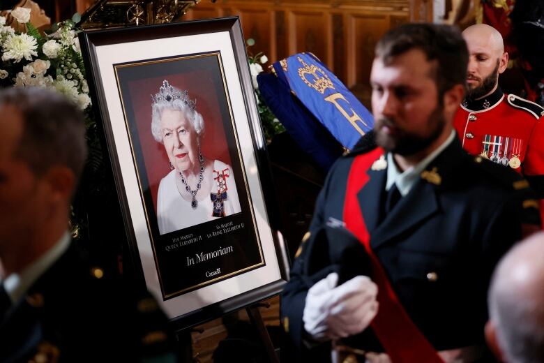 Pallbearers walk past a portrait of the late Sovereign during commemorative ceremonies for Queen Elizabeth at Christ Church Cathedral, in Ottawa