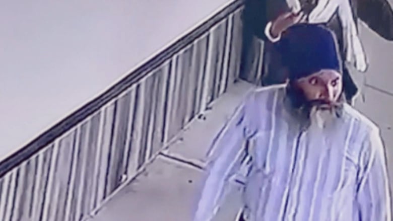 An Indian man in a blue turban and blue shirt on security footage