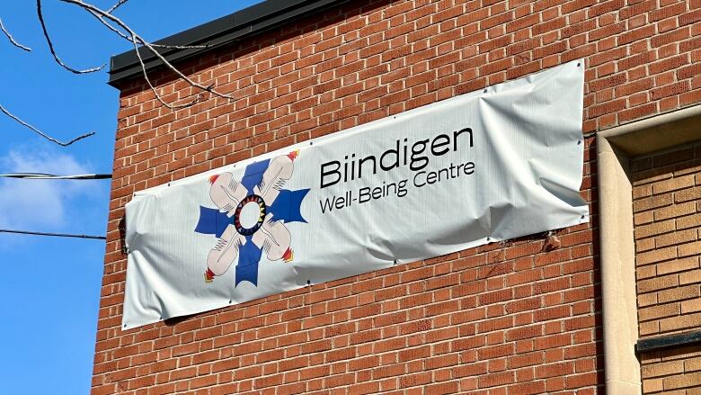 A sign on a building reading Biindigen Well-Being Centre.