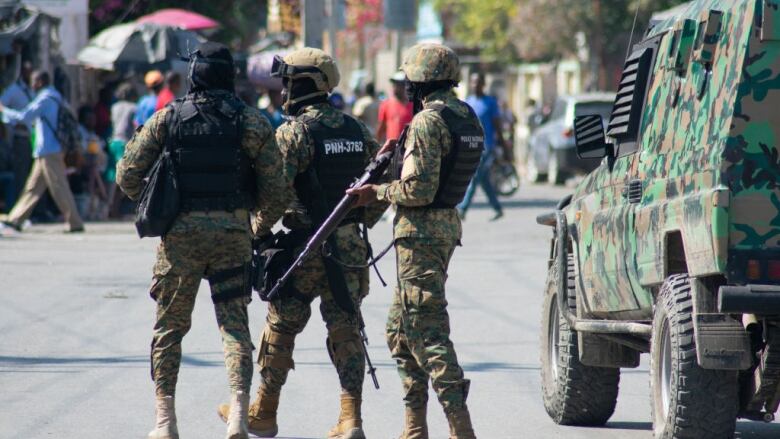 Heavily armed Haitian police officers walk the streets in Port-au-.Prince