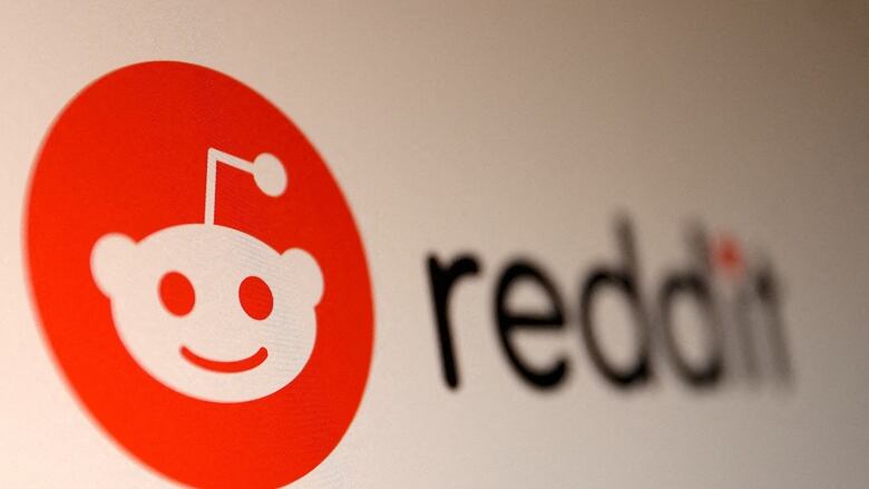 A logo of a small alien in a red circle appears next to the word Reddit. 