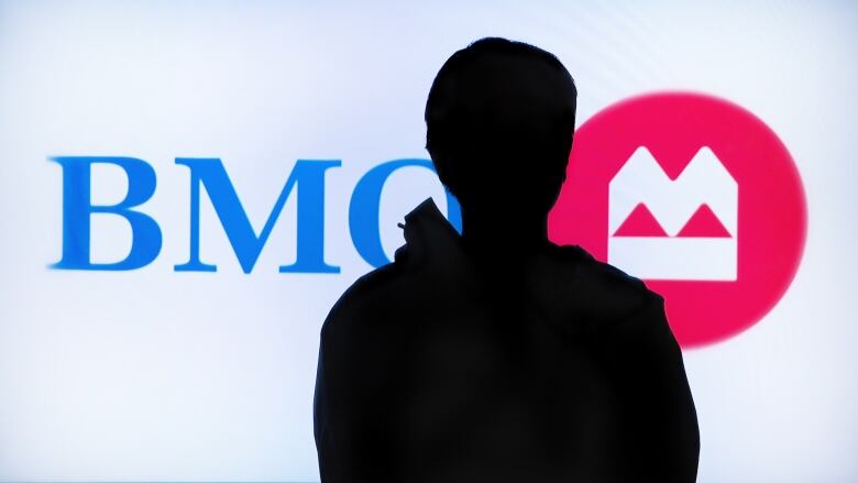 An anonymous figure in front of a bank of montreal logo.