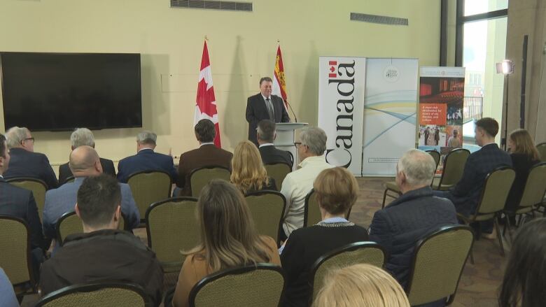 Premier Dennis King speaks to a room of people.