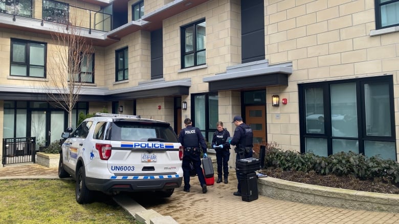 Police outside a multi-unit residential building.