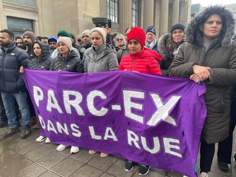 A group of women hold up a banner.