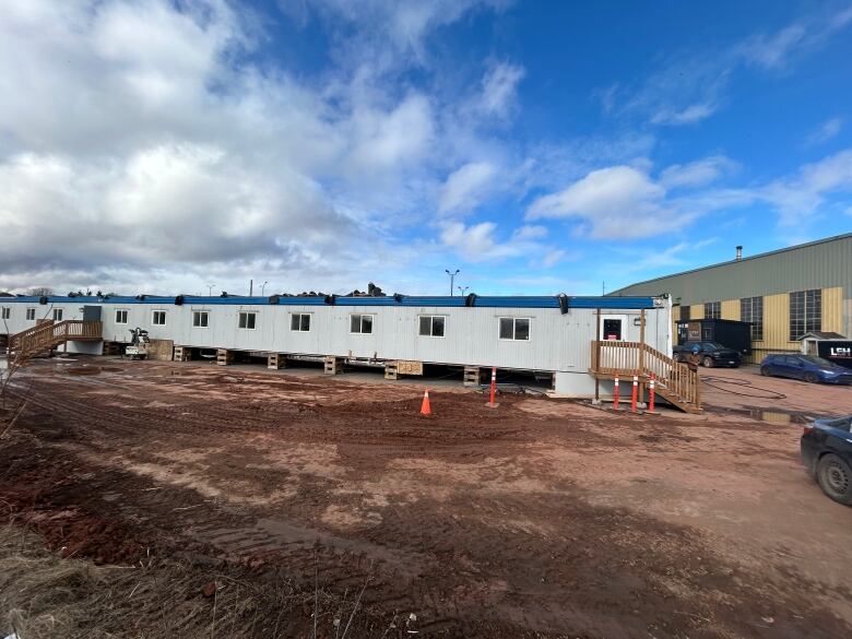 A mobile unit sits in a muddy parking lot.