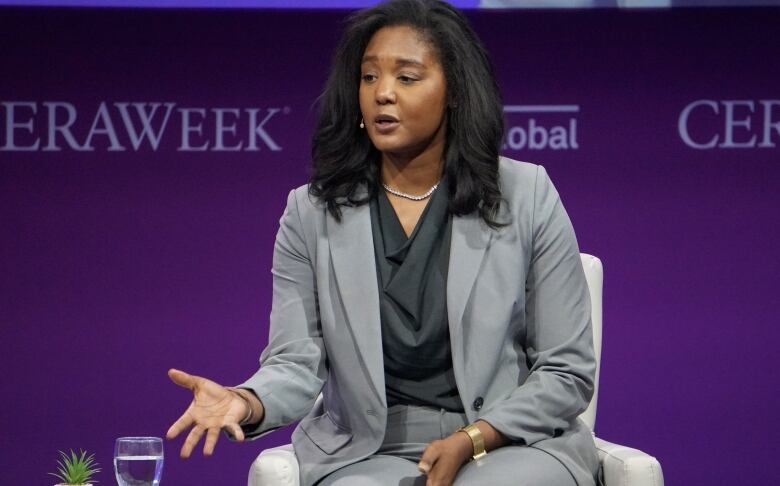 A woman is speaking on stake at a conference.