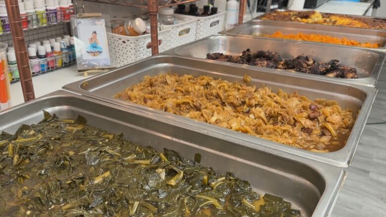 Picture of large dishes of collard greens, grilled chicken, candied yams and macaroni and cheese.