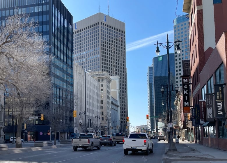 Street scene in downtown, showing cars and buildings.