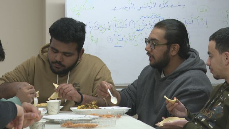 Men sit at a table and eat