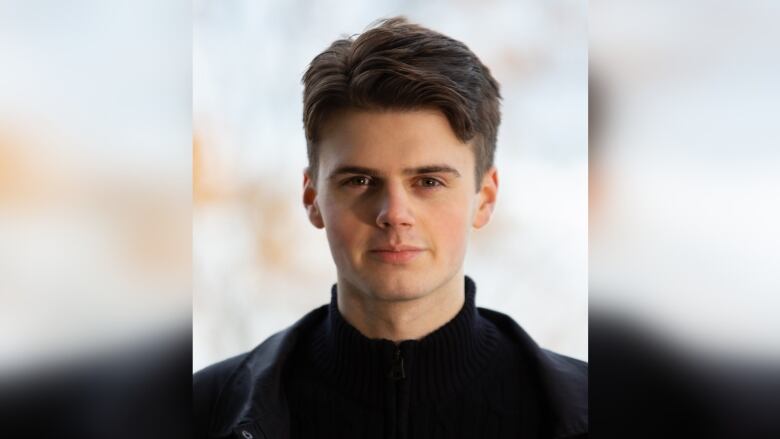 An unsmiling young man with brown hair