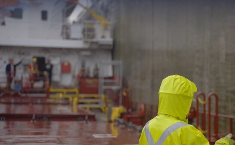 Workers are shown on a Canadian shipping freighter.