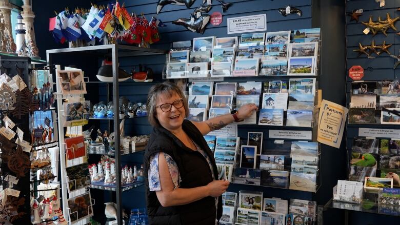 Kierra Maher arranges postcards in her shop, Newfoundland to Nanaimo. 