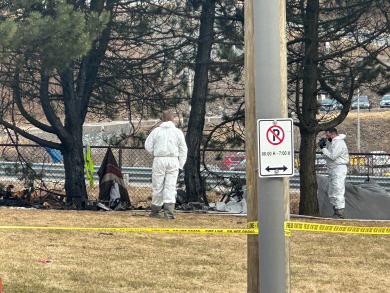 Men in white suits investigate the scene