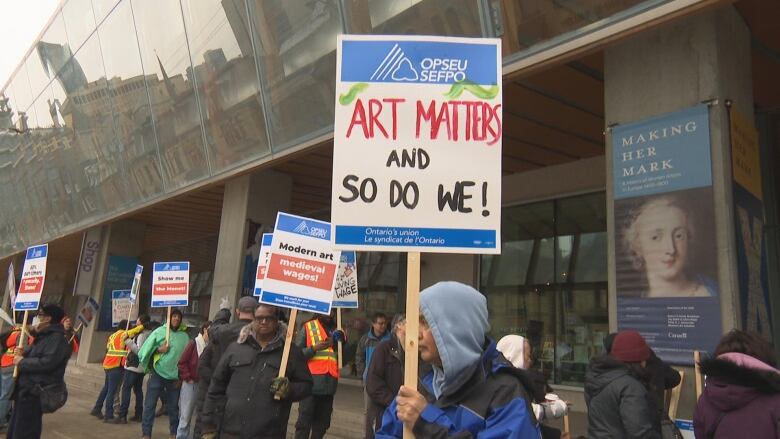 A worker holds a sign that reads: 