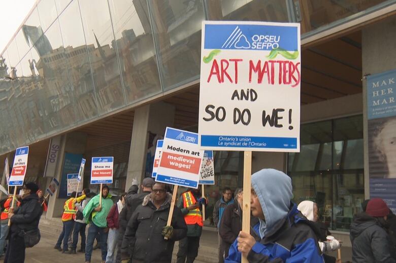 A worker holds a sign that reads: 