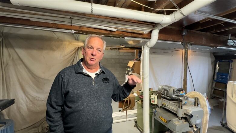 Bob barnes stands next white tubing in his basement