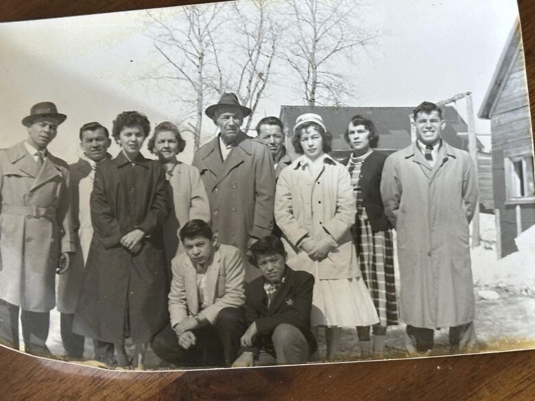 A black-and-white photograph shows several people standing together for a group photo.