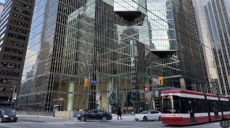 A city street corner with a streetcar going by.