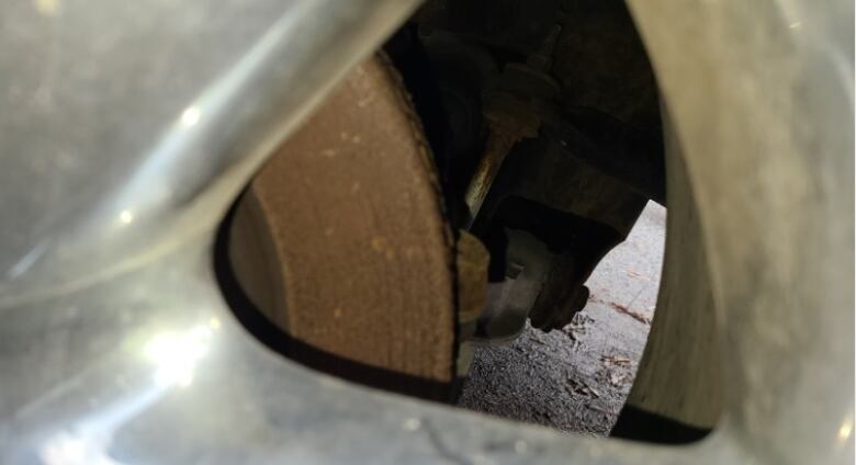 Rust is seen on the brake rotor of a vehicle's wheel. 