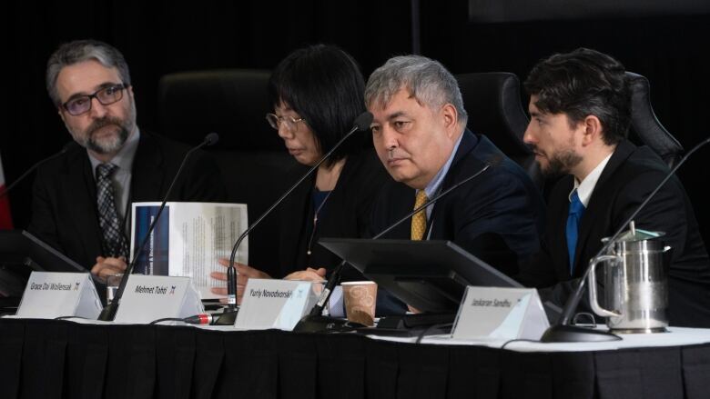 Four people sit at a conference table