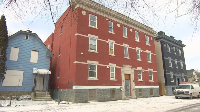 A red brick building is shown in winter.