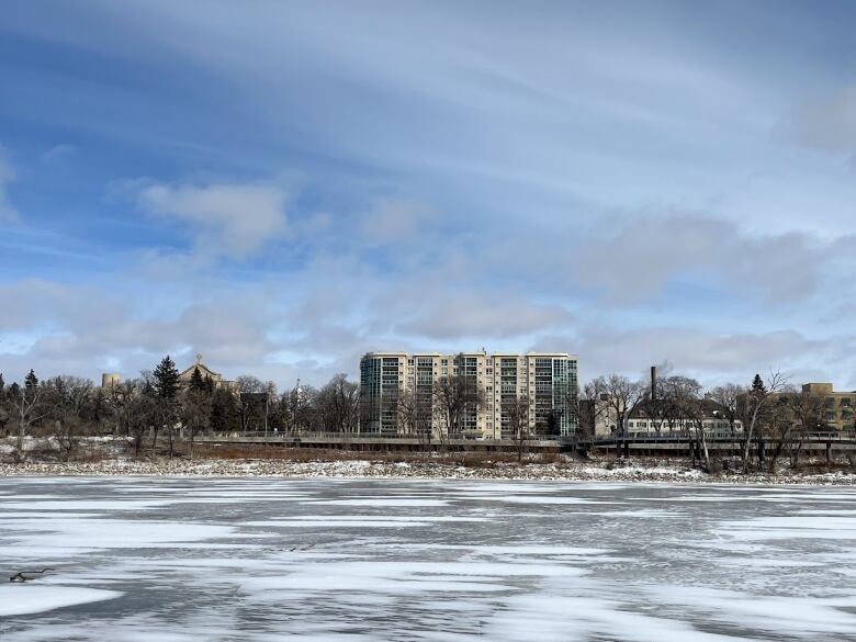 Buildings are seen on the opposite bank of an icy river.