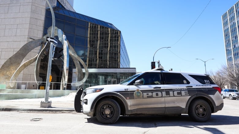 Close up of police car in front of a downtown building.