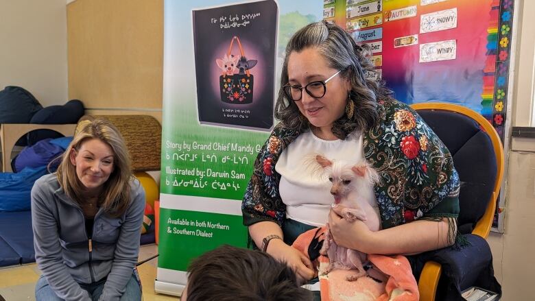 A woman holds a dog in her arms. 