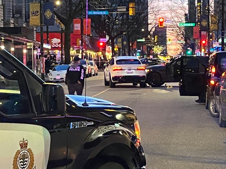 A black SUV sits perpendicular to a white SUV on Robson Street.