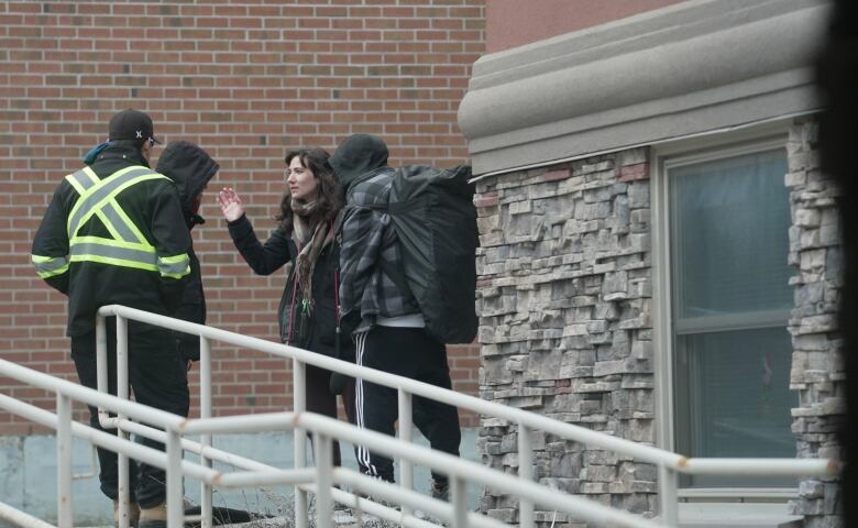 A woman speaking with three men.