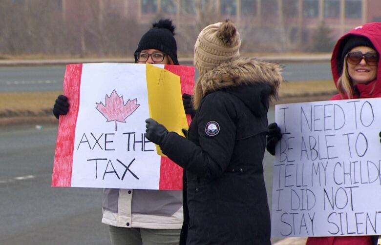 People hold signs reading 