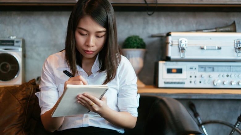 Woman writing in the notebook.