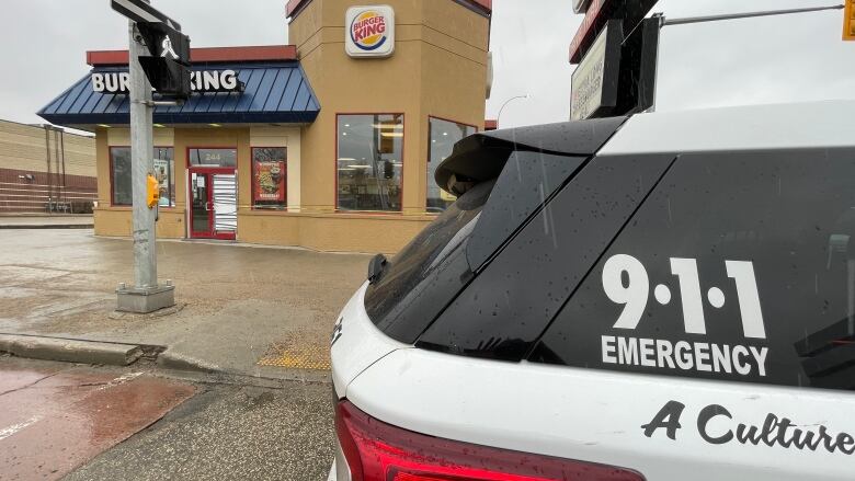 A police car sits outside a restaurant.