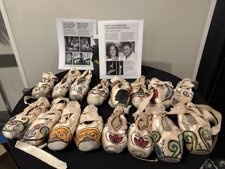 A table display shows several pairs of hand-designed, patterned moccasins. 