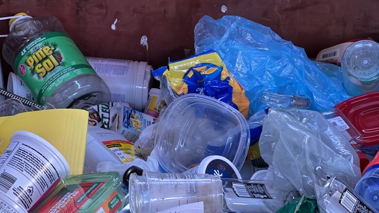 Plastic containers and bags in a bin.