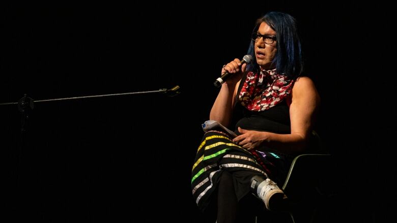 A woman speaks into a microphone.