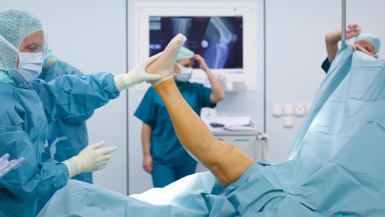 Doctors and medical staff work during knee prosthesis surgery in Switzerland.