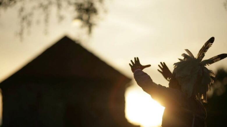 Shadow of a man and building; depth of field gives perception he's capturing the sun.