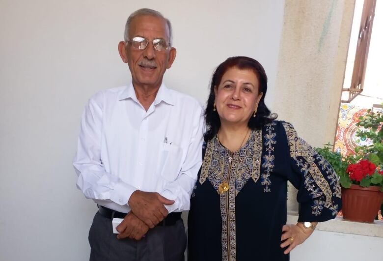 An elderly couple smile for a photo