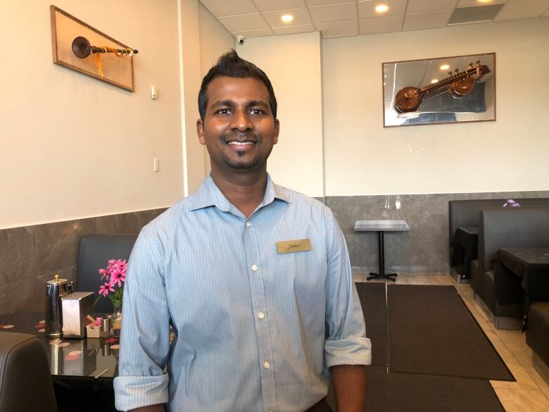 A man standing in the middle of an Indian restaurant 