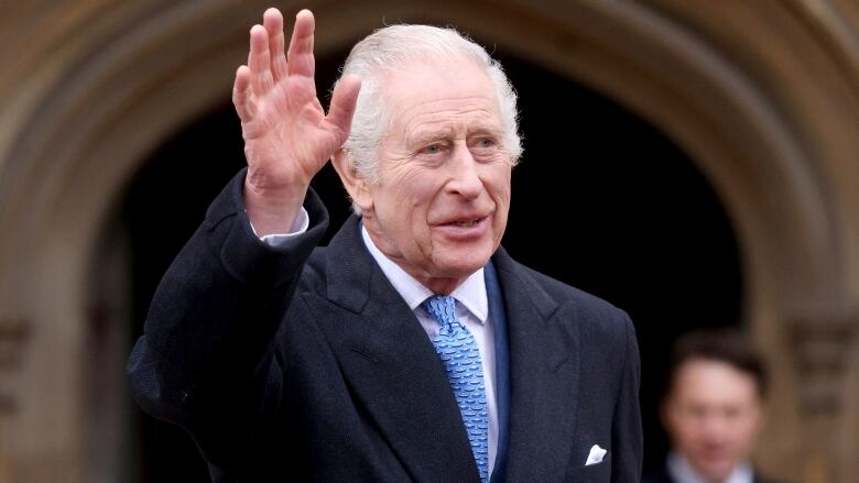 A person waves while leaving a chapel.