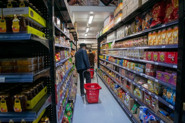 People in the aisle of a grocery store.