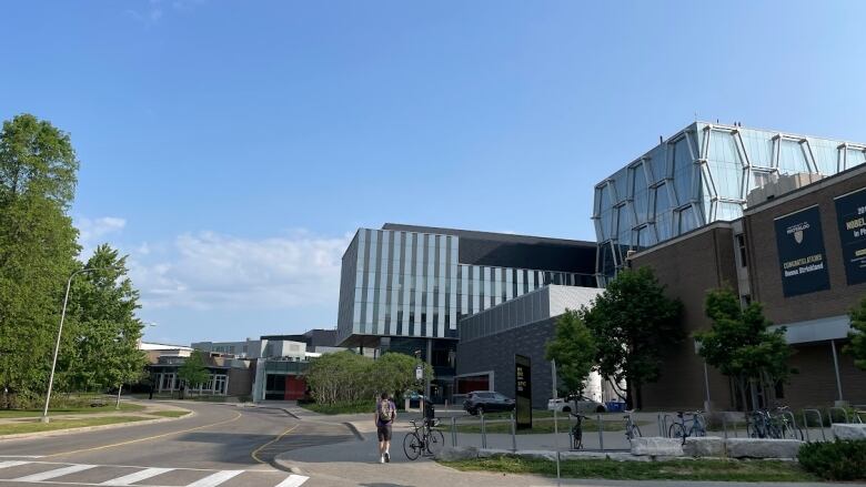 Student walking away from camera on university campus.