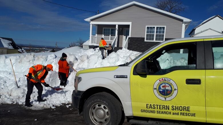 Search and rescue volunteers help shovel paths to homes of people in need of aid in the aftermath of February's heavy snowfall in Cape Breton. 