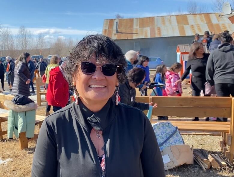 A smiling woman wearing sunglasses