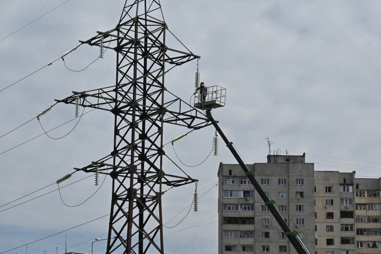 A worker makes repairs to a power line in Kharkiv, Ukraine, in the aftermath of Russian missile strikes on Saturday.